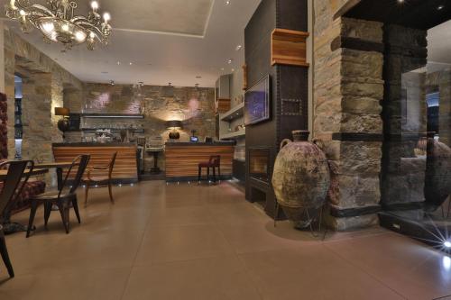 una sala da pranzo con parete in pietra, tavolo e sedie di Forvm boutique Hotel a Trieste