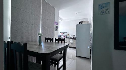 a kitchen with a wooden table and a refrigerator at Apartamento Praia de Navegantes Beto Carrero Balneário Camboriú in Navegantes
