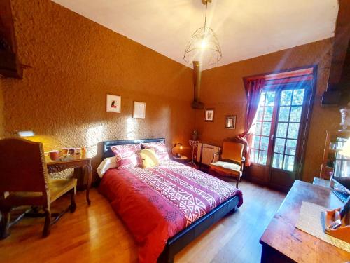Schlafzimmer mit einem Bett, einem Schreibtisch und einem Fenster in der Unterkunft Cottage Saint Martin in Ozolles