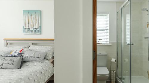a bedroom with a bed and a glass shower at Wee Jules By The Sea in Anstruther