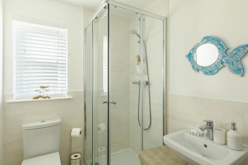 a bathroom with a shower and a toilet and a sink at Wee Jules By The Sea in Anstruther