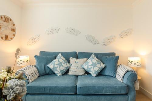 a blue couch with pillows in a living room at Wee Jules By The Sea in Anstruther