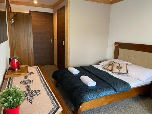 a bedroom with a bed with two pillows on it at Willa Królewska - Wellness SPA - widokowe Pokoje i Apartamenty in Kościelisko