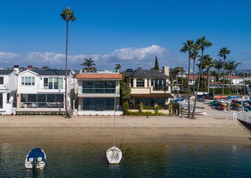 a boat in the water in front of a house at 367 Via Lido Soud home in Newport Beach