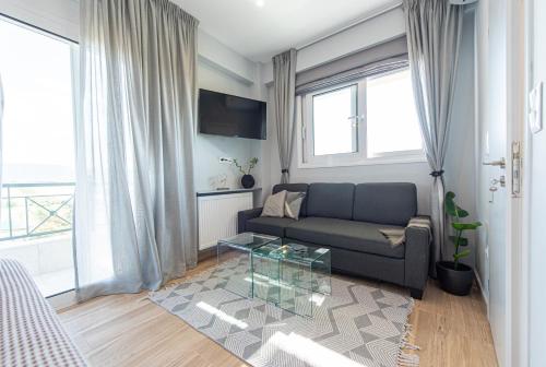 a living room with a couch and a glass table at Masticha Apartment in Oinófita