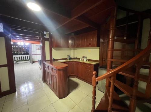 eine Küche mit Holzschränken und eine Treppe darin in der Unterkunft Duplex in historical heart of the Plaza San Martín in Lima