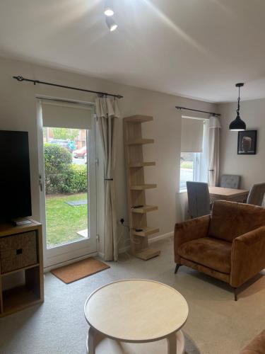 a living room with a couch and a table at The Retreat at Harlow in Potter Street