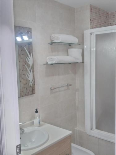 ein Bad mit einem Waschbecken, einer Dusche und einem Spiegel in der Unterkunft Atico Duplex 1ª in Xilxes