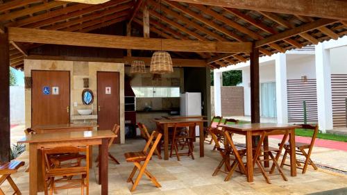 eine Küche und ein Esszimmer mit Holztischen und Stühlen in der Unterkunft Paraíso Barra Grande in Barra Grande