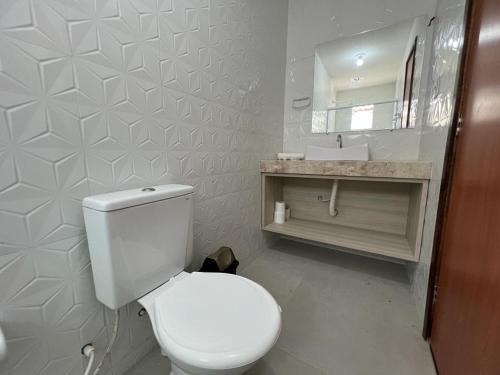 ein Badezimmer mit einer weißen Toilette und einem Waschbecken in der Unterkunft Paraíso Barra Grande in Barra Grande