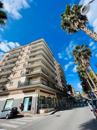 a tall building on a city street with palm trees at Interno Sei B&B in Agropoli