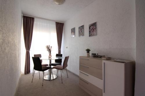 une chambre avec une table, des chaises et une fenêtre dans l'établissement Happy Residence Sibiu, à Sibiu