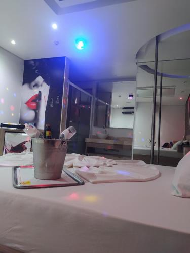 a room with a painting of a woman on a table at MOTEL LA FOLIA in Ribeirão Preto