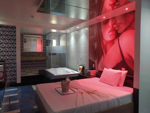 a room with a bed and a bathroom with a mirror at MOTEL LA FOLIA in Ribeirão Preto