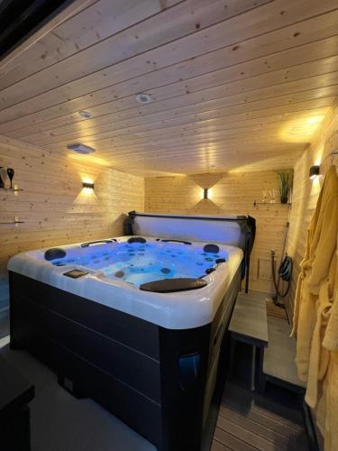 un jacuzzi dans une pièce aux murs en bois dans l'établissement Les suites de Stanislas jacuzzi & spa, à Nancy