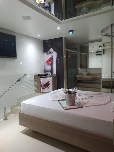 a bedroom with a large bed and a bathroom at MOTEL LA FOLIA in Ribeirão Preto