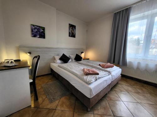 um quarto com uma cama, uma secretária e uma janela em Alcorso Pension em Banská Bystrica