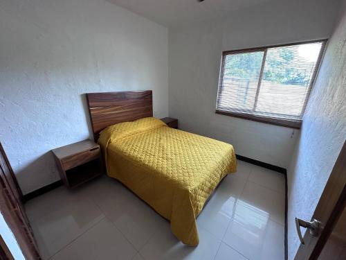 a small bedroom with a bed and a window at Suite las palmas excelente depa con alberca in Manzanillo