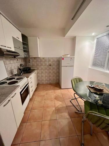 a kitchen with white appliances and a table in it at Aleks 4 in Skopje