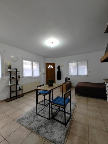 a living room with a table and chairs and a bed at Cosy Studio in Pont-de-lʼArche
