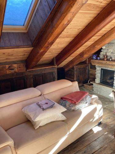 um sofá branco num quarto com lareira em Villa millefiori falda argentera em Sauze di Cesana