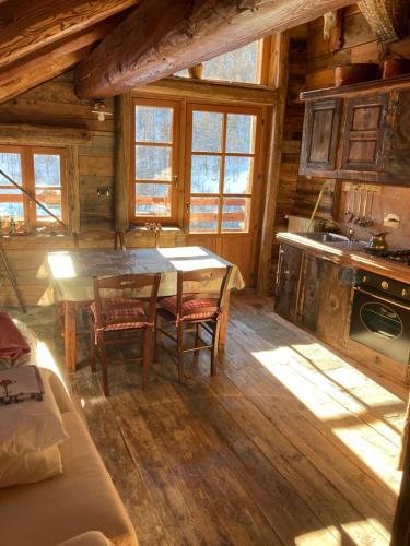 a kitchen with a table and chairs in a cabin at Villa millefiori falda argentera in Sauze di Cesana