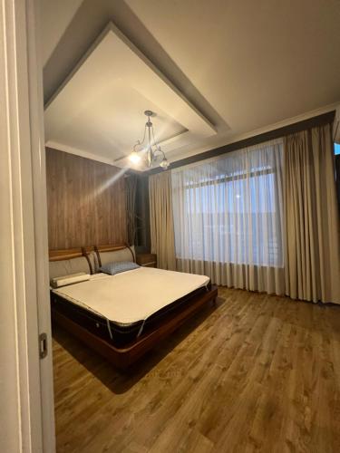 een slaapkamer met een bed en een groot raam bij Lisi villa in Tkhinvali