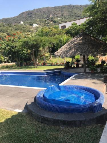 a swimming pool with a blue tub next to a house at Casa Quinta Joselito in Jiutepec
