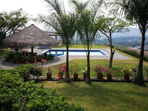 a resort with a swimming pool and palm trees at Casa Quinta Joselito in Jiutepec