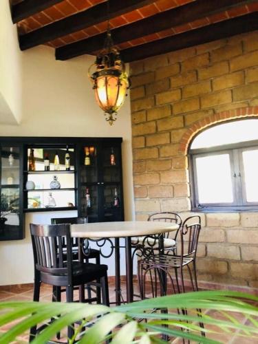 a table and chairs in a room with a brick wall at Casa Quinta Joselito in Jiutepec