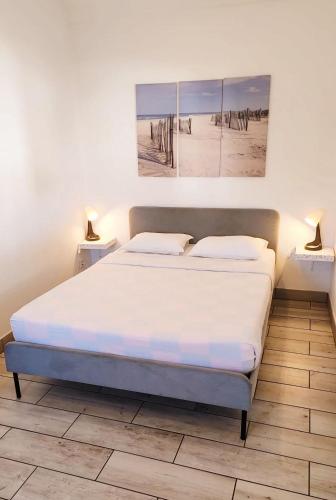 a bed in a bedroom with a picture of the beach at Blife Faro Beach Hostel & Rooms in Faro