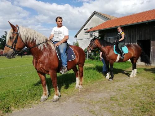 a man and a woman sitting on a horse at Ponyhof Adam Urlaub auf dem Bauernhof in Eschlkam