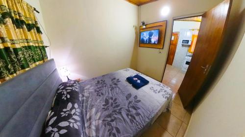uma pequena cama num pequeno quarto com televisão em Lumay em Puerto Iguazú