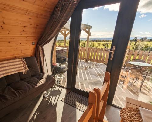 a living room with a couch and a screened in porch at Timber Valley Pods in Galston