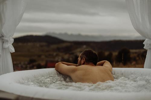 a man sitting in a bath tub at Loft&Hill in Grywałd