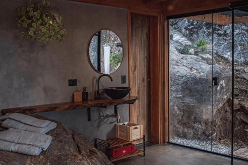 a bathroom with a sink and a mirror on the wall at Cabana Carcará in São Bento do Sapucaí