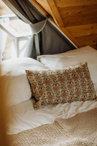 a pillow sitting on top of a bed at Loft&Hill in Grywałd