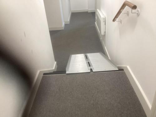 a hallway with a staircase with a book on the floor at Sophia's Cwtch in Cardiff
