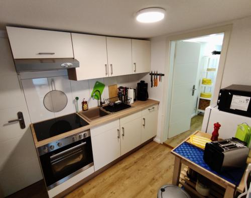 a kitchen with white cabinets and a stove top oven at Ferienwohnung Thomsdorf in Thomsdorf