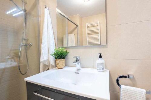 a bathroom with a white sink and a shower at Coimbra Etxea Precioso piso recién estrenado in Bermeo