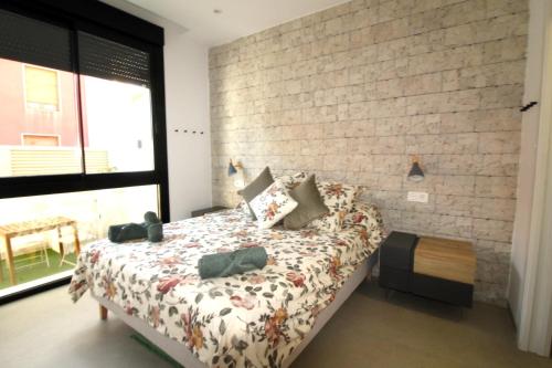 een slaapkamer met een bed en een bakstenen muur bij Elvira Home, Santiago de la Ribera, AQ-156 in Santiago de la Ribera
