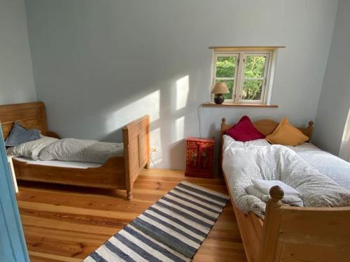 a bedroom with two beds and a window at Wohnung in historischem Pfarrhof auf Rügen in Poseritz