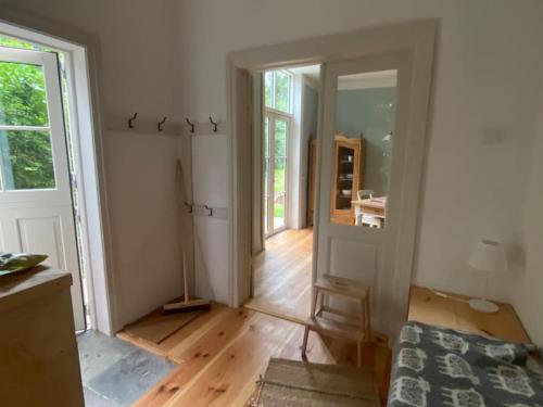 ein leeres Zimmer mit einem Bett und einem Zimmer mit einer Tür in der Unterkunft Wohnung in historischem Pfarrhof auf Rügen in Poseritz