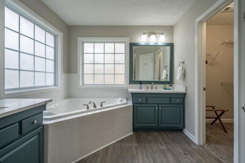 a bathroom with a tub and a sink at Spacious 3BR Home on Sprawling Serene Grounds in Kingston