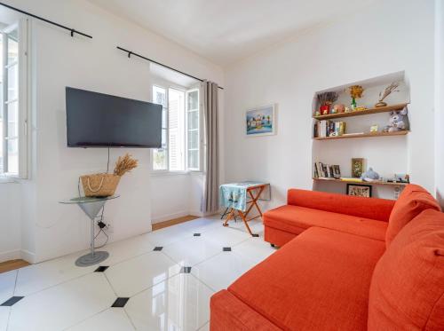 a living room with a red couch and a flat screen tv at Appartement Claudia - Central - Very close to Sea - Calm - AC in Nice