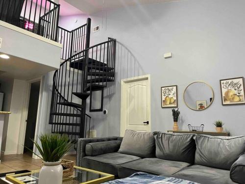 a living room with a couch and a staircase at Desert Getaway - Luxury Condo Loft in Chandler