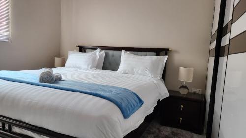 a bedroom with a large bed with a blue blanket at Chez Gabrielle in Lusaka