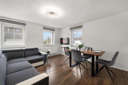 a living room with a couch and a table at ADN Suites - NETFLIX - modern and smart in Günzburg