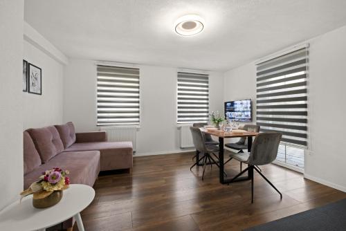 a living room with a couch and a table at ADN Suites - NETFLIX - modern and smart in Günzburg