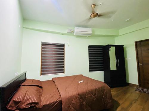 a bedroom with a bed and a ceiling fan at AL-Kabeer Lavender budget rooms in Trivandrum